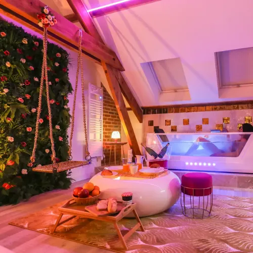 Espace détente avec bain balnéo dans une love room